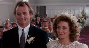 Movie still from “What About Bob?” (1991), directed by Frank Oz – A man and a woman standing next to each other in front of a crowd; Close Up shot, Over the shoulder angle