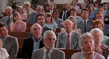 Movie still from “What About Bob?” (1991), directed by Frank Oz – A group of people sitting in rows in a church; Wide shot, High angle