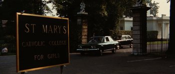 Movie still from “What Have You Done to Solange?” (1972), directed by Massimo Dallamano – Cars parked on the side of the road in front of a building; Extreme Wide shot, High angle