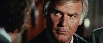 Movie still from “What Have You Done to Solange?” (1972), directed by Massimo Dallamano – An older man in a suit looking at the camera; Close Up shot, Over the shoulder angle