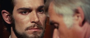 Movie still from “What Have You Done to Solange?” (1972), directed by Massimo Dallamano – A person with a beard looking at another person; Close Up shot, Over the shoulder angle