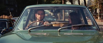 Movie still from “What Have You Done to Solange?” (1972), directed by Massimo Dallamano – A man and a woman sitting in the back seat of a green car; Medium shot, Over the shoulder angle