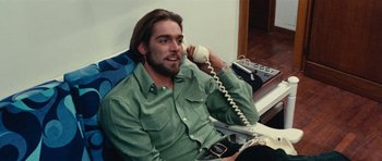 Movie still from “What Have You Done to Solange?” (1972), directed by Massimo Dallamano – A man sitting down talking on a phone; Medium shot, Low angle