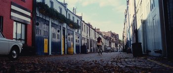 Movie still from “What Have You Done to Solange?” (1972), directed by Massimo Dallamano – A woman riding a bike down a street; Extreme Wide shot, High angle