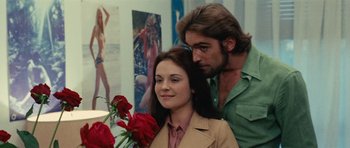 Movie still from “What Have You Done to Solange?” (1972), directed by Massimo Dallamano – A man and a woman holding a bunch of roses; Medium shot, Low angle