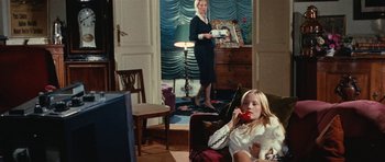 Movie still from “What Have You Done to Solange?” (1972), directed by Massimo Dallamano – A woman standing in front of a television and another woman sitting on a chair; Wide shot, High angle