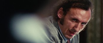Movie still from “What Have You Done to Solange?” (1972), directed by Massimo Dallamano – A person wearing a suit and tie; Close Up shot, Over the shoulder angle