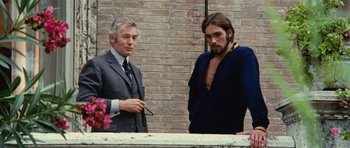 Movie still from “What Have You Done to Solange?” (1972), directed by Massimo Dallamano – Two men standing next to each other in front of a brick wall; Medium shot, Low angle