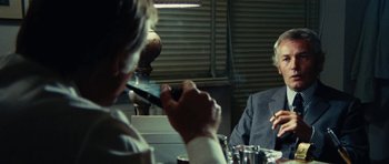 Movie still from “What Have You Done to Solange?” (1972), directed by Massimo Dallamano – A man smoking a cigarette in front of another man; Close Up shot, Over the shoulder angle