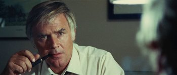Movie still from “What Have You Done to Solange?” (1972), directed by Massimo Dallamano – An older man wearing a white shirt and tie; Close Up shot, Over the shoulder angle