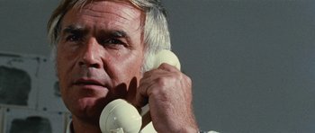 Movie still from “What Have You Done to Solange?” (1972), directed by Massimo Dallamano – An older man talking on two white phones; Close Up shot, Low angle