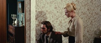 Movie still from “What Have You Done to Solange?” (1972), directed by Massimo Dallamano – A man and a woman are sitting in a room together; Medium shot, High angle