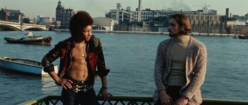 Movie still from “What Have You Done to Solange?” (1972), directed by Massimo Dallamano – Two men standing next to each other near a body of water; Medium shot, Low angle