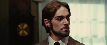 Movie still from “What Have You Done to Solange?” (1972), directed by Massimo Dallamano – A man in a suit and tie with a beard; Close Up shot, Low angle