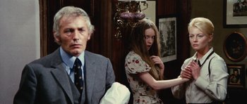 Movie still from “What Have You Done to Solange?” (1972), directed by Massimo Dallamano – A man and a woman sitting in front of each other in a room; Medium shot, Over the shoulder angle
