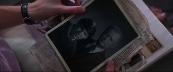 Movie still from “What Lies Beneath” (2000), directed by Robert Zemeckis – A person holding a photo of a man and a woman; Close Up shot, High angle