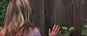 Movie still from “What Lies Beneath” (2000), directed by Robert Zemeckis – A woman standing in front of a wooden fence; Close Up shot, Over the shoulder angle