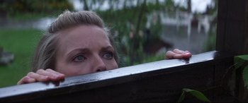 Movie still from “What Lies Beneath” (2000), directed by Robert Zemeckis – A person with blue eyes peeking over a bench; Close Up shot, Low angle