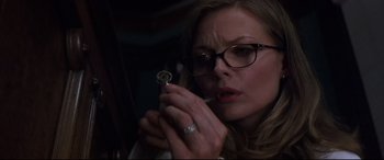 Movie still from “What Lies Beneath” (2000), directed by Robert Zemeckis – A woman holding a key in her hand and looking at the camera; Close Up shot, High angle