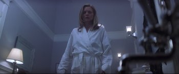 Movie still from “What Lies Beneath” (2000), directed by Robert Zemeckis – A woman in a white bathrobe standing in front of a mirror; Medium shot, Low angle