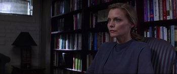Movie still from “What Lies Beneath” (2000), directed by Robert Zemeckis – A woman sitting in front of a book shelf in a library; Close Up shot, Over the shoulder angle