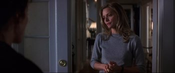 Movie still from “What Lies Beneath” (2000), directed by Robert Zemeckis – A woman standing in front of an open door in a room; Medium shot, Over the shoulder angle