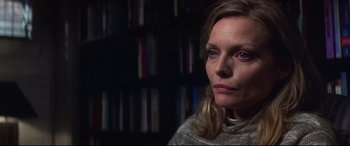 Movie still from “What Lies Beneath” (2000), directed by Robert Zemeckis – A person sitting in front of a book shelf; Close Up shot, Low angle