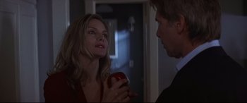 Movie still from “What Lies Beneath” (2000), directed by Robert Zemeckis – A woman holding an apple in front of a man; Close Up shot, Over the shoulder angle