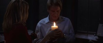 Movie still from “What Lies Beneath” (2000), directed by Robert Zemeckis – A person holding a candle in their hands; Close Up shot, Over the shoulder angle
