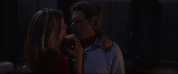 Movie still from “What Lies Beneath” (2000), directed by Robert Zemeckis – A man and a woman kissing in a dark room; Medium shot, Over the shoulder angle