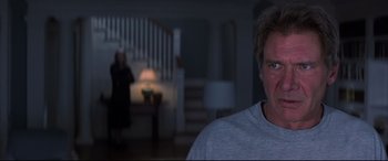 Movie still from “What Lies Beneath” (2000), directed by Robert Zemeckis – A man standing in front of a staircase in a house; Close Up shot, Over the shoulder angle