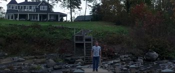 Movie still from “What Lies Beneath” (2000), directed by Robert Zemeckis – A man standing in front of stairs on a hill; Wide shot, Low angle