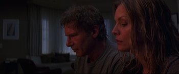 Movie still from “What Lies Beneath” (2000), directed by Robert Zemeckis – A man and a woman sitting next to each other in a living room; Close Up shot, Low angle