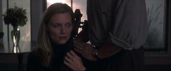 Movie still from “What Lies Beneath” (2000), directed by Robert Zemeckis – A man is holding a woman's face while she is holding a cello; Close Up shot, Over the shoulder angle