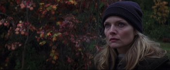 Movie still from “What Lies Beneath” (2000), directed by Robert Zemeckis – A person wearing a hat near a tree; Close Up shot, Low angle