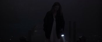 Movie still from “What Lies Beneath” (2000), directed by Robert Zemeckis – A woman is holding a flashlight in the dark; Medium shot, High angle