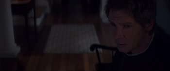 Movie still from “What Lies Beneath” (2000), directed by Robert Zemeckis – A man sitting on a chair in a room; Close Up shot, High angle