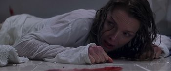 Movie still from “What Lies Beneath” (2000), directed by Robert Zemeckis – A woman laying on the ground with blood on her hands; Close Up shot, Overhead angle