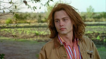 Movie still from “What's Eating Gilbert Grape” (1993), directed by Lasse Hallström – A man with long red hair wearing a brown jacket; Close Up shot, Low angle