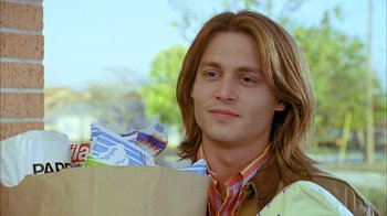 Movie still from “What's Eating Gilbert Grape” (1993), directed by Lasse Hallström – A man holding a paper bag with food in front of him; Close Up shot, Low angle