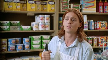 Movie still from “What's Eating Gilbert Grape” (1993), directed by Lasse Hallström – A man holding a pair of scissors in a store; Medium shot, Low angle