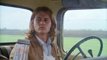 Movie still from “What's Eating Gilbert Grape” (1993), directed by Lasse Hallström – A man with long hair sitting in the driver's seat of a truck; Close Up shot, Over the shoulder angle