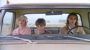 Movie still from “What's Eating Gilbert Grape” (1993), directed by Lasse Hallström – A group of people sitting in the back of a car; Medium shot, Over the shoulder angle