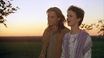 Movie still from “What's Eating Gilbert Grape” (1993), directed by Lasse Hallström – A man and a woman standing next to each other in a field; Medium shot, Low angle