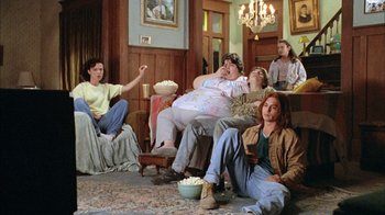 Movie still from “What's Eating Gilbert Grape” (1993), directed by Lasse Hallström – A group of people sitting in a living room watching tv; Wide shot, High angle