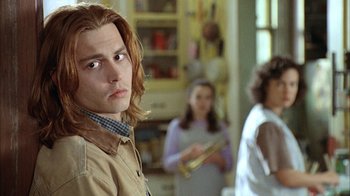 Movie still from “What's Eating Gilbert Grape” (1993), directed by Lasse Hallström – A man with long red hair is looking straight ahead; Close Up shot, Over the shoulder angle