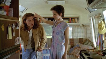 Movie still from “What's Eating Gilbert Grape” (1993), directed by Lasse Hallström – A woman is touching the hair of another woman; Medium shot, Low angle