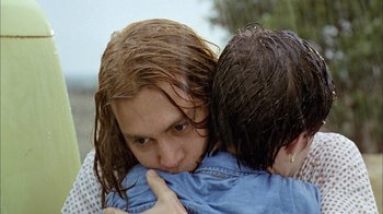 Movie still from “What's Eating Gilbert Grape” (1993), directed by Lasse Hallström – A woman hugging another woman with wet hair; Close Up shot, Overhead angle