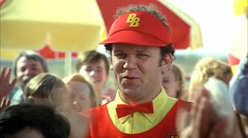 Movie still from “What's Eating Gilbert Grape” (1993), directed by Lasse Hallström – A man wearing a red hat and a yellow vest; Close Up shot, Over the shoulder angle