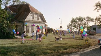 Movie still from “What's Eating Gilbert Grape” (1993), directed by Lasse Hallström – A group of people in a yard with kites; Extreme Wide shot, High angle